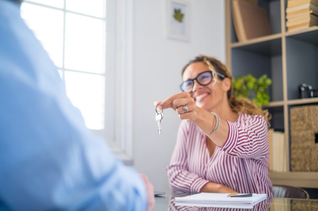 Crop close up of realtor give keys to man buyer or renter buying first home from agency.